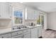 Kitchen with white cabinets, stainless steel sink, and backyard access at 116 Westover Ave, Kannapolis, NC 28081