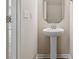 Small powder room with pedestal sink and octagon mirror at 12515 Bryton Ridge Pkwy, Huntersville, NC 28078