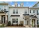 Three-story townhome with gray, white, and blue siding, a green door, and stone accents at 12515 Bryton Ridge Pkwy, Huntersville, NC 28078