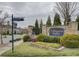 Elegant stone entrance sign for The Courtyards at Marvin, surrounded by manicured landscaping and flowering plants at 1255 Restoration Dr, Waxhaw, NC 28173