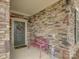 Close-up of the front porch featuring a decorative wreath, stone wall, and a charming pink bench at 1255 Restoration Dr, Waxhaw, NC 28173