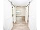 Bright hallway with white barn doors and wood-look flooring at 139 Elysian Dr, Mooresville, NC 28117