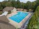 Aerial view of community pool with lounge chairs and surrounding landscape at 15604 Wynford Hall St, Huntersville, NC 28078