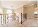 Upstairs hallway with wood railing and neutral carpeting at 15604 Wynford Hall St, Huntersville, NC 28078