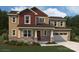 Two-story house with a blend of neutral and burgundy siding, stone accents, and a two-car garage at 1709 Honey Trl, Monroe, NC 28112