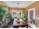 Sunlit dining room features a wood table, blue chairs, and abundant plants at 2706 White Pines Ct, Monroe, NC 28112