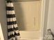 Bathroom with tub shower and black and white striped curtain at 306 Union St, Maiden, NC 28650