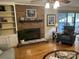 Living room with brick fireplace, built-in shelving, hardwood floors, and sliding glass doors leading to a deck at 3165 Wimbledon Ln, Rock Hill, SC 29732