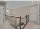 Upstairs hallway with chandelier, window, and wrought iron railing at 4119 Flint Dr, Lancaster, SC 29720