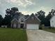 Brick two-story house with a large driveway and landscaped lawn at 4305 Chatterleigh Dr, Monroe, NC 28110