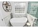 Bright bathroom featuring a freestanding soaking tub with modern fixtures and a decorative shelf at 503 Bridgestone Ct, Gastonia, NC 28056