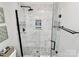 Modern bathroom with a glass shower featuring black hardware and marble tiling at 503 Bridgestone Ct, Gastonia, NC 28056