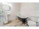 Bathroom with clawfoot tub, pedestal sink, and white wainscoting at 506 S Chester St, Gastonia, NC 28052