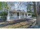 Charming white house with a wraparound porch and mature trees in the front yard at 506 S Chester St, Gastonia, NC 28052