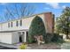 Tan and brick townhouse with a tree and gated entrance at 5915 Quail Hollow Rd # E, Charlotte, NC 28210