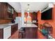 Kitchen with dark brown cabinets, an island, and orange walls at 5915 Quail Hollow Rd # E, Charlotte, NC 28210