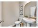 Clean bathroom with pedestal sink, toilet, and decorative mirror at 6265 Six String Ct, Fort Mill, SC 29708