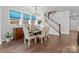 Elegant dining room with hardwood floors, a wooden table, and staircase view at 703 Marion Dr, Matthews, NC 28105