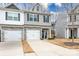 Two-story townhome with gray siding, stone accents, and a two-car garage at 7216 Somerford Rd, Charlotte, NC 28215