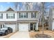 Two-story townhome with gray siding, stone accents, and a two-car garage at 7216 Somerford Rd, Charlotte, NC 28215