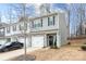 Two-story townhome with gray siding, stone accents, and a two-car garage at 7216 Somerford Rd, Charlotte, NC 28215