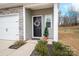 Modern black front door with a wreath, located on a stone-accented home at 7216 Somerford Rd, Charlotte, NC 28215