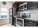 Modern kitchen with dark cabinets, granite countertops, and stainless steel appliances at 7216 Somerford Rd, Charlotte, NC 28215