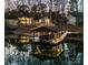 Night view of home, garage, and lakefront dock at 7476 Point St, Denver, NC 28037