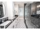 Spa-like bathroom with black marble tile and frameless glass shower at 7476 Point St, Denver, NC 28037