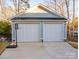 Two-car garage with white doors and basketball hoop at 7476 Point St, Denver, NC 28037