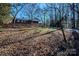 Large backyard with leaf covered ground and wooden fence at 940 Valley Dr, Newton, NC 28658