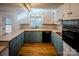 U-shaped kitchen with teal cabinets, tile counters, and breakfast bar at 940 Valley Dr, Newton, NC 28658