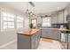 Updated kitchen boasts an island with butcher block top and stylish pendant lighting at 941 Squirrel Hill Rd, Charlotte, NC 28213