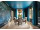 Elegant dining room with blue ceiling and curtains featuring a statement chandelier above a glass table at 1108 Ardsley Rd, Charlotte, NC 28207