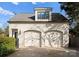 Detached two car garage featuring carriage doors, an upper level window, and stylish exterior lighting at 1108 Ardsley Rd, Charlotte, NC 28207