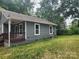 Gray house with brown porch and side yard with green grass at 1302 Brookdale St, Kannapolis, NC 28083