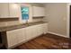White kitchen cabinets, granite countertops, and a double sink at 1302 Brookdale St, Kannapolis, NC 28083