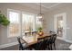 Kitchen dining area with wooden table, black chairs, and large windows overlooking backyard at 2010 Belle Grove Dr, Marvin, NC 28173