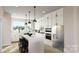 Stylish kitchen with white cabinets, stainless steel appliances, a large island, and modern pendant lighting at 309 Old Town Village Rd, Waxhaw, NC 28173