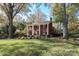 Brick home with a classic design, mature trees, and well-manicured lawn at 3810 Rhodes Ave, Charlotte, NC 28210