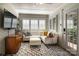 Cozy sunroom with white sectional sofa, wood-look flooring, and brick feature wall at 3810 Rhodes Ave, Charlotte, NC 28210