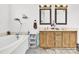 Bright bathroom featuring a soaking tub and a double sink vanity with framed mirrors at 7918 Ridgeview Dr, Sherrills Ford, NC 28673