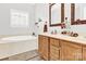 Bright bathroom with a soaking tub, double sinks, and wood vanity at 7918 Ridgeview Dr, Sherrills Ford, NC 28673