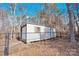 An exterior shot of an outbuilding shed with white siding and a chain-link fence at 7918 Ridgeview Dr, Sherrills Ford, NC 28673