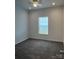 Bright bedroom features plush carpeting, a ceiling fan, and a window bringing in natural light at 819 Wellwood Ave, Statesville, NC 28677