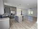 Open kitchen and living area with gray cabinetry, stainless appliances, and light hardwood floors at 819 Wellwood Ave, Statesville, NC 28677