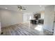 Open-concept living room with gray flooring, white walls, ceiling fan, and eat-in kitchen at 819 Wellwood Ave, Statesville, NC 28677