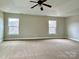 Bright bedroom with carpet, tray ceiling, and natural light from two windows at 9034 Seamill Rd, Charlotte, NC 28278