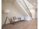 Basement sitting area with staircase, light wood floors, and two armchairs at 1214 S Kings Dr # A, Charlotte, NC 28207
