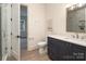 Clean bathroom with a navy vanity, a shower behind glass, and a view of the next room at 1214 S Kings Dr # A, Charlotte, NC 28207